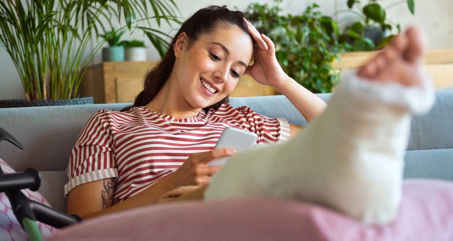 woman in a cast looking at a mobile phone