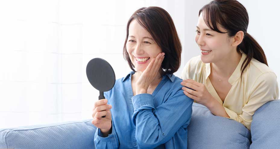 two women looking at teeth in mirror