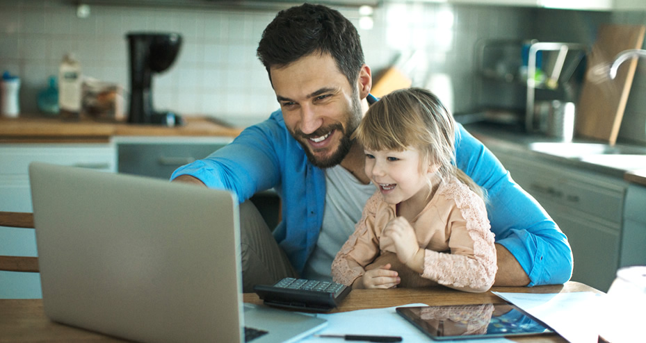 father and daughter using a laptop computer