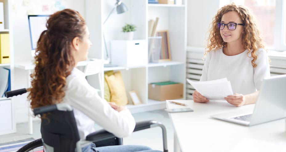 woman in wheelchair paying bill at doctors office