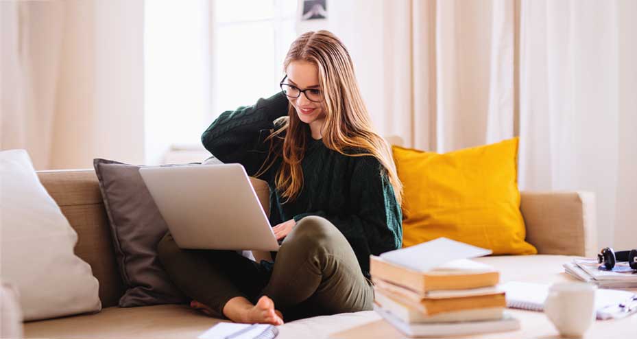 woman sitting on the couch looking at laptop
