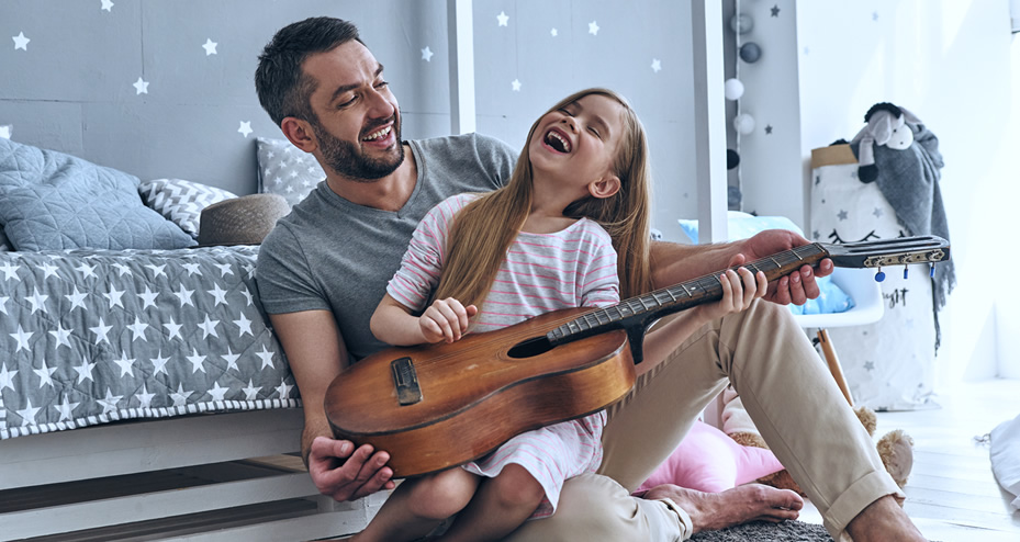 father and daughter playing a guitar