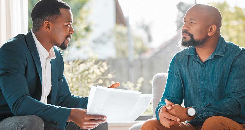 two men talking over paperwork