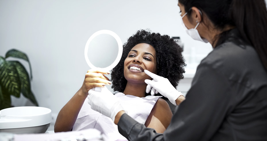 dentist talking with patient, looking in a mirror