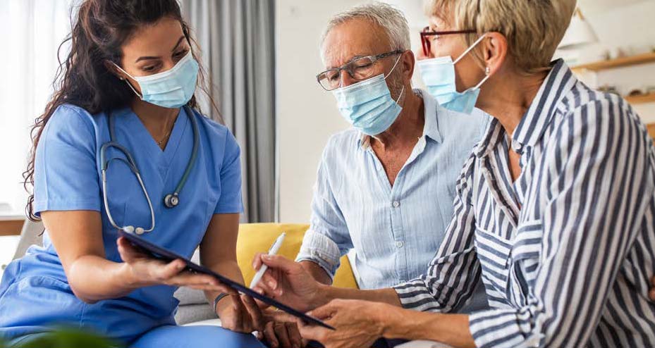 healthcare worker helping couple fill out paperwork