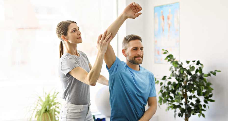 physical therapist helping patient stretch his arm