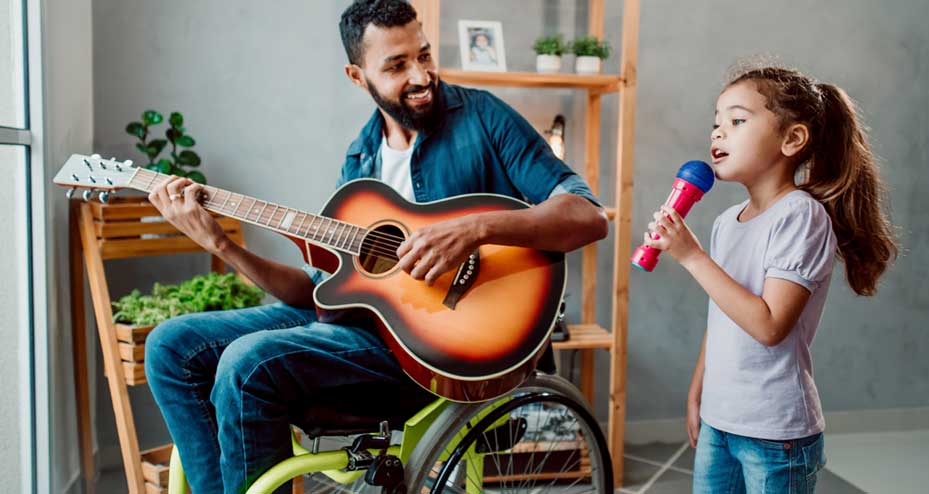 father in wheelchair playing guitar, daughter singing along